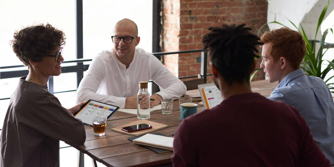 Group of estate agents sat around desk in office