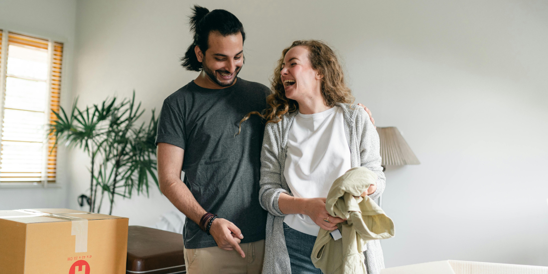 Couple laughing and moving home