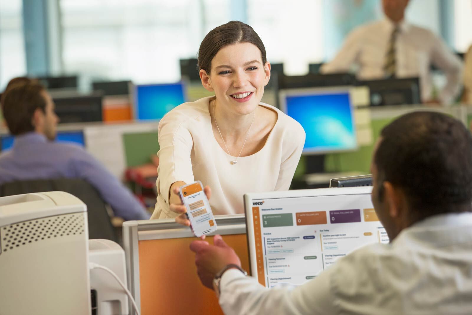 Office worker sharing Veco Plus on mobile device to another office worker