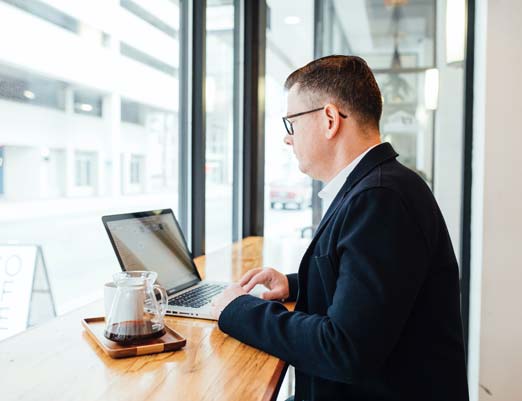 Agent on laptop sitting in cafe