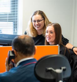 Staff supporting each other at desk