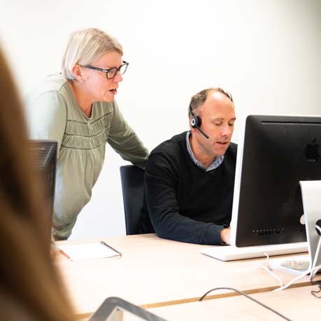 Two member of staff looking at computer