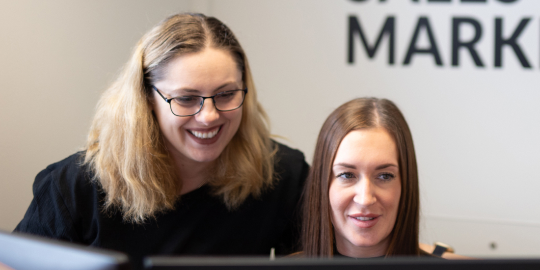 Veco staff smiling and looking at computer